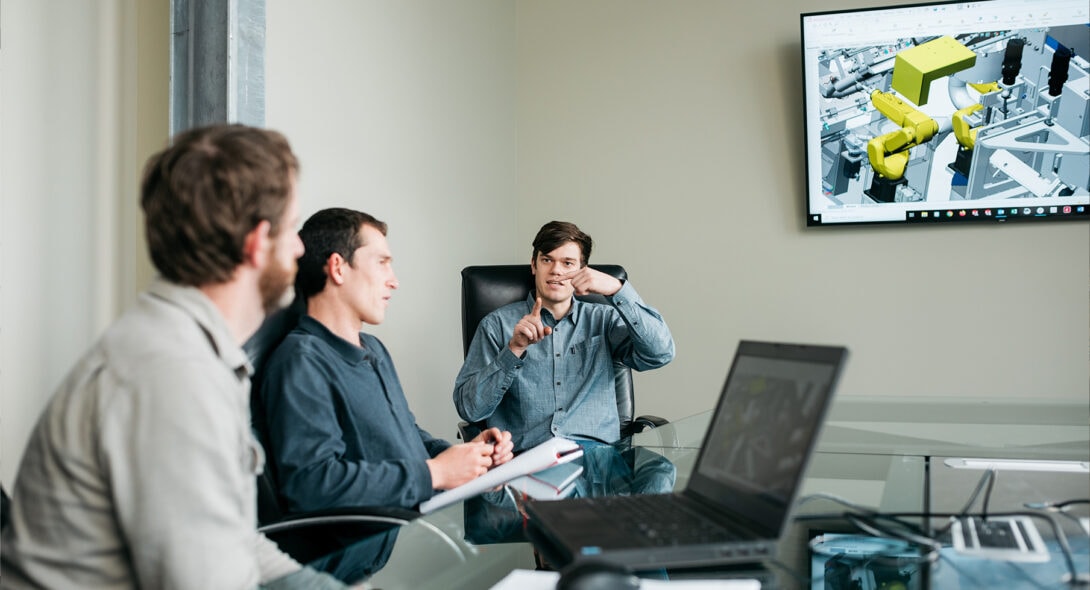 Three team members in discussion in conference room