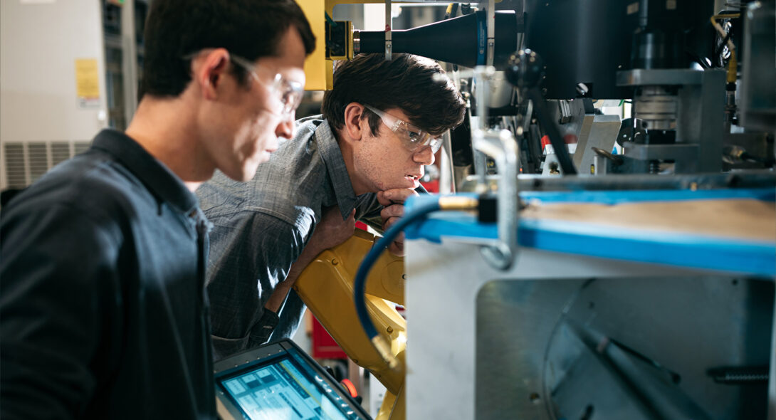 Two team members in deep work over a machine